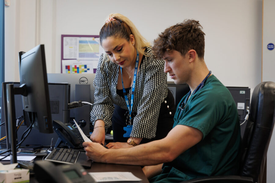 GP staff talking at computer desk